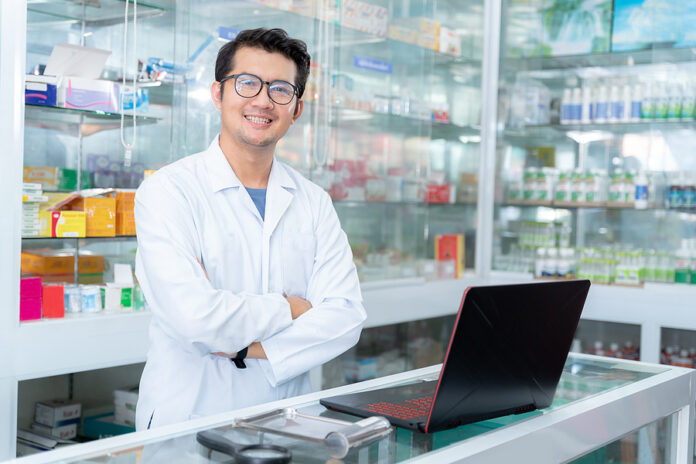 Happy Pharmacist Working In Chemist Shop Or Pharmacy. Pharmacist